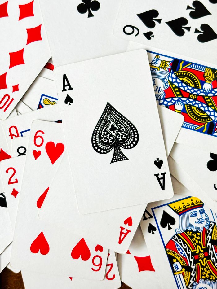 Mastering the First Impression: Your intriguing post title goes here A scattered deck featuring the Ace of Spades and various playing cards.