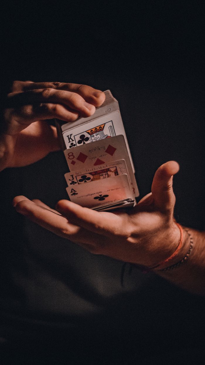 Crafting Captivating Headlines: Your awesome post title goes here A close-up of hands skillfully performing a card trick with playing cards.